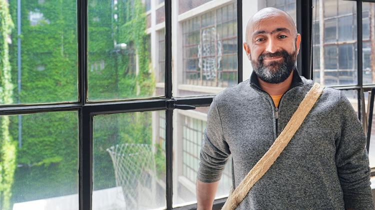 Man with beard standing by window