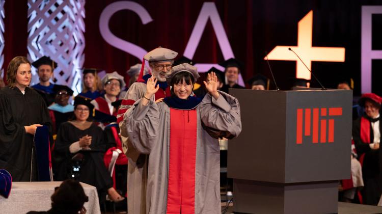 MAS PHD graduate receives hood on stage 