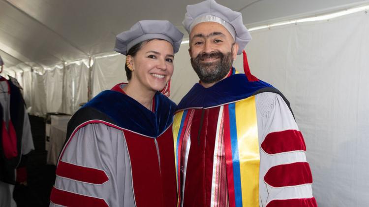 PHD graduate smiles with faculty member at reception