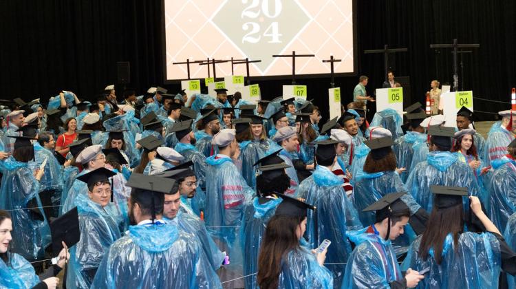 candid photo of large group of graduates lining up for procession